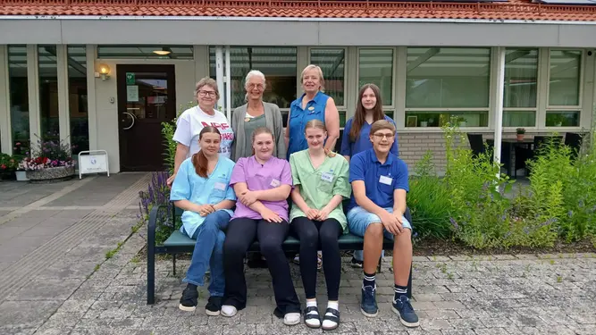 Tre av arbetsgruppens medlemmar tillsammans med fem feriearbetande ungdomar.